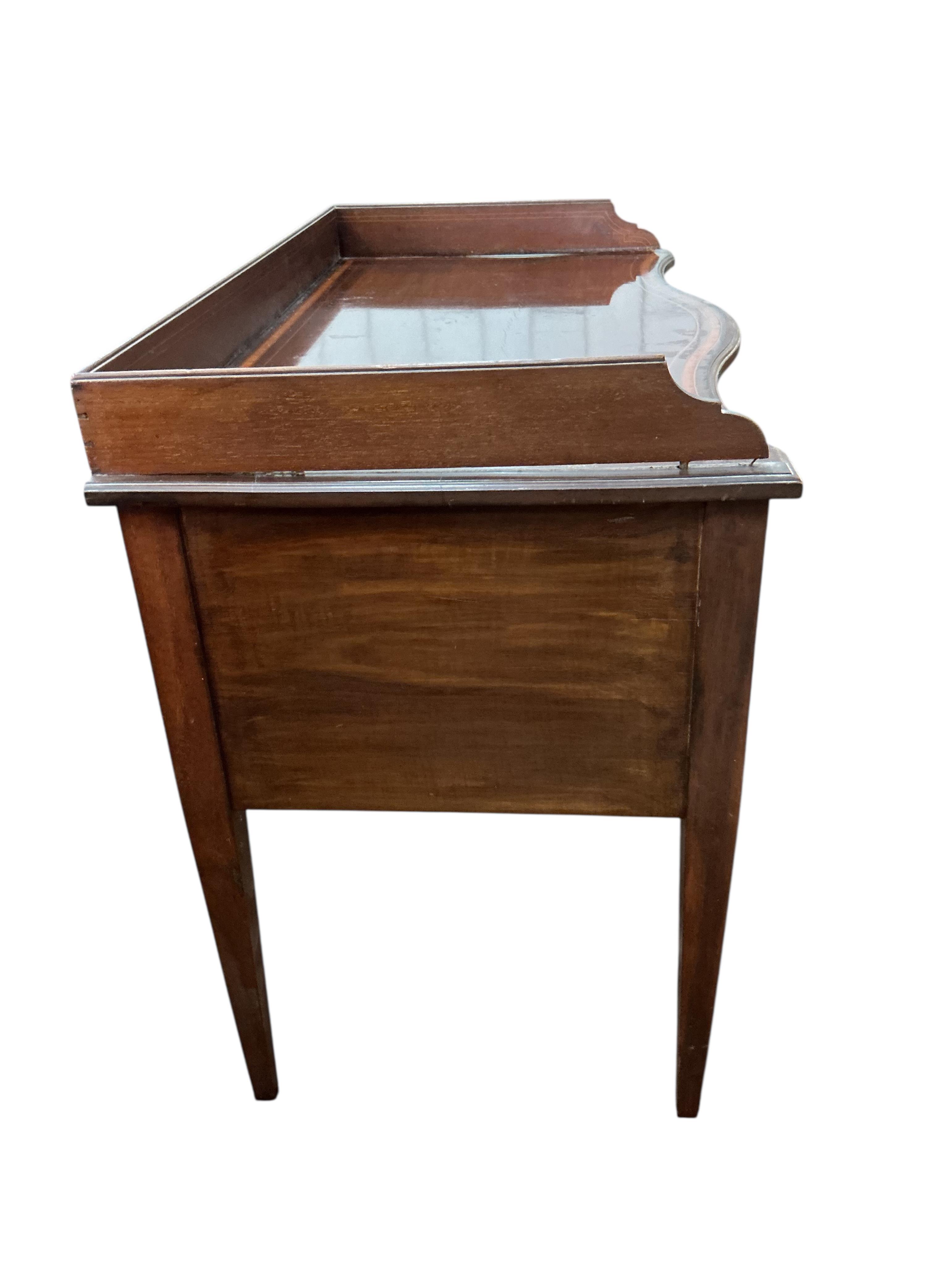An Edwardian satinwood banded serpentine mahogany dressing table, on tapered legs, width 106cm, depth 54cm, height 82cm